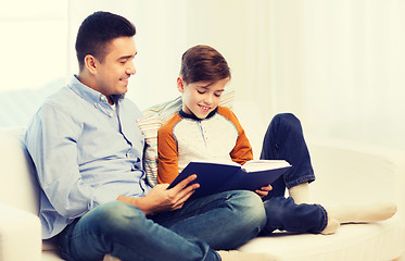 Image showing happy father and son reading book at home