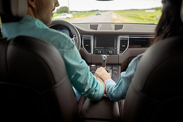 Image showing happy couple driving in car and holding hands