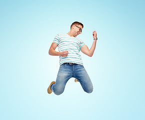 Image showing happy man jumping and playing imaginary guitar