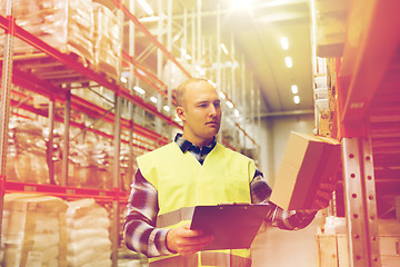 Image showing man with clipboard in safety vest at warehouse