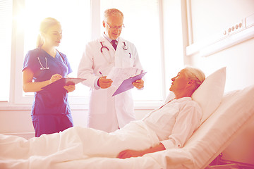 Image showing doctor and nurse visiting senior woman at hospital