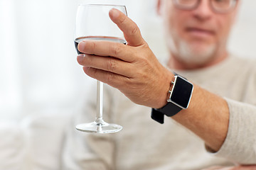 Image showing senior man drinking red wine from glass at home