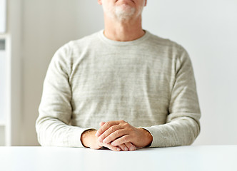 Image showing close up of senior man hands on table