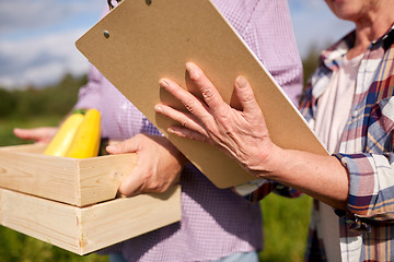 Image showing happy senior couple with squashes at farm