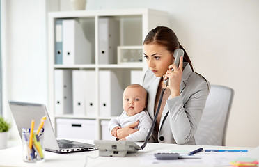 Image showing businesswoman with baby calling on phone at office