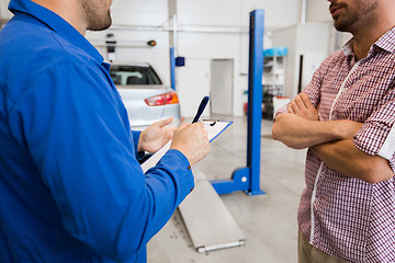 Image showing auto mechanic with clipboard and man at car shop