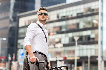 Image showing young man with bicycle on city street