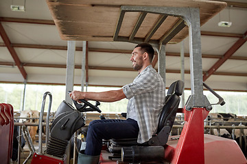 Image showing man or farmer driving tractor at farm