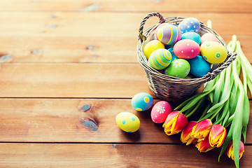 Image showing close up of easter eggs in basket and flowers