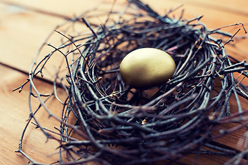 Image showing close up of golden easter egg in nest on wood