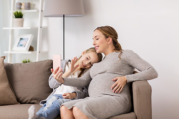 Image showing pregnant woman and girl taking smartphone selfie