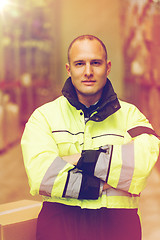 Image showing man in coveralls with box at warehouse