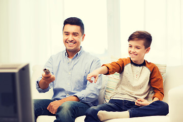 Image showing smiling father and son watching tv at home