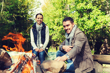 Image showing happy couple roasting marshmallow over camp fire