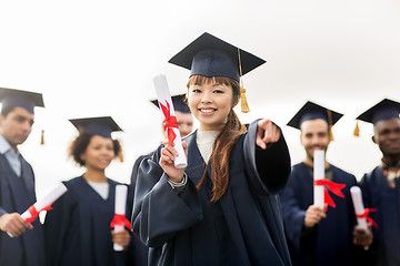 Image showing happy student with diploma pointing finger at you