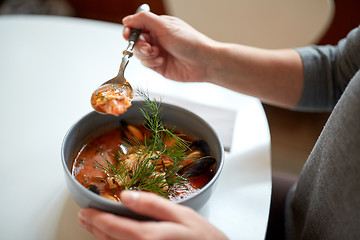 Image showing woman eating seafood soup at restaurant