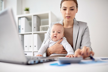 Image showing happy businesswoman with baby and laptop at office