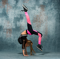 Image showing Young girl break dancing on wall background.