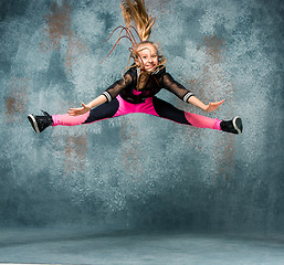 Image showing Young girl break dancing on wall background.