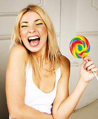 Image showing young pretty blonde girl with colorful candy happy smiling, emotional posing, lifestyle people concept