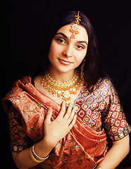 Image showing beauty sweet real indian girl in sari smiling on black background, jewelry shining 