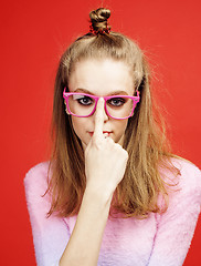 Image showing young pretty emitonal posing teenage girl on bright red background, happy smiling lifestyle people concept 