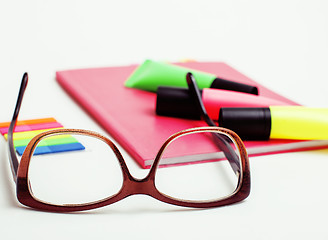 Image showing business, education and technology concept - close up of notebook, paper stickers, glasses, pencil different new stuff on white background