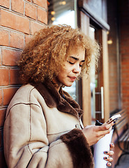 Image showing young pretty african american women drinking coffee outside in cafe, modern real business woman lifestyle concept