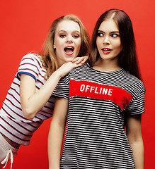 Image showing two best friends teenage girls together having fun, posing emotional on red background, besties happy smiling, lifestyle people concept close up