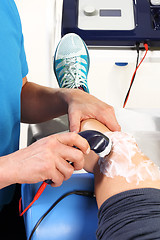 Image showing Physiotherapy, ultrasound Physiotherapist doctor performs surgery on a patient's leg