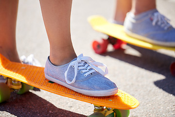 Image showing close up of feet riding skateboards on city street