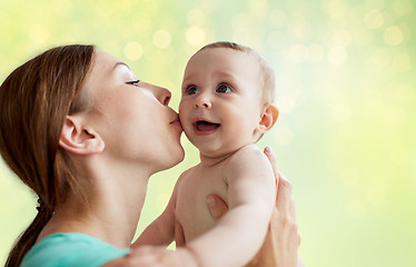 Image showing happy young mother kissing little baby