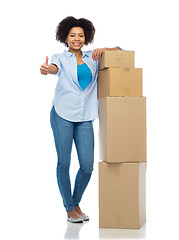 Image showing happy african woman with boxes showing thumbs up