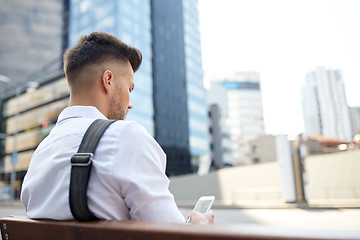 Image showing close up of man texting on smartphone in city