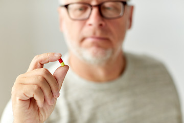 Image showing close up of senior man with medicine pill