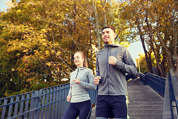 Image showing happy couple running downstairs in city