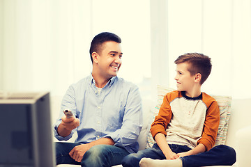 Image showing smiling father and son watching tv at home