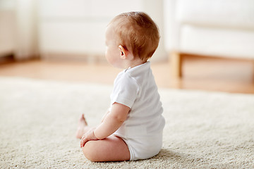 Image showing happy baby boy or girl sitting on floor at home