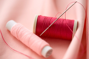 Image showing red thread spool on cloth