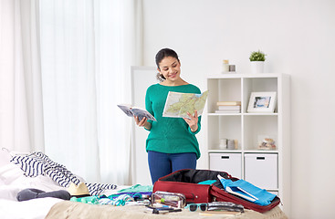 Image showing woman packing travel bag at home or hotel room