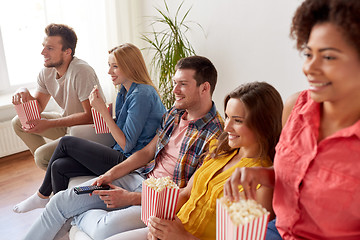 Image showing happy friends with popcorn watching tv at home