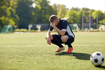 Image showing sad soccer player with ball on football field