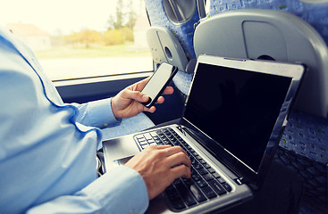 Image showing man with smartphone and laptop in travel bus