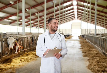 Image showing veterinarian with cows in cowshed on dairy farm