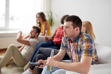 Image showing friends with popcorn and beer watching tv at home