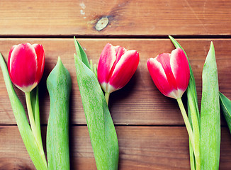 Image showing close up of red tulip flowers on wooden table