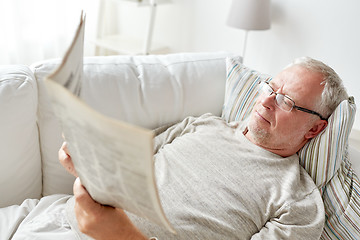 Image showing close up of senior man reading newspaper at home