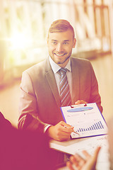 Image showing smiling businessman with graph at business meeting