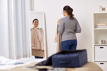 Image showing woman packing travel bag at home or hotel room