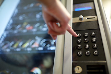 Image showing hand pushing button on vending machine keyboard